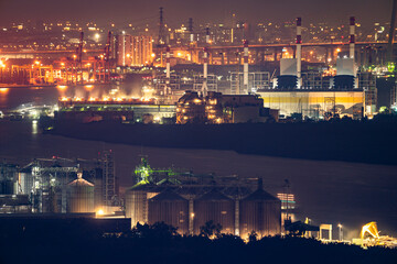 Fototapeta premium Aerial view of industrial area, factory, port and harbour in Bangkok city, Thailand at night time.
