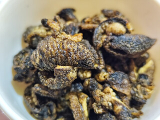 Flourless snail chips have a savory, delicious and crunchy taste. Presented with a white bowl with a natural blur background.