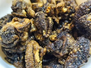 Flourless snail chips have a savory, delicious and crunchy taste. Presented with a white bowl with a natural blur background.