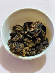Flourless snail chips have a savory, delicious and crunchy taste. Presented with a white bowl with a natural blur background.