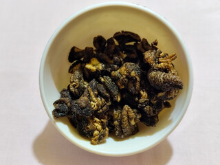 Flourless snail chips have a savory, delicious and crunchy taste. Presented with a white bowl with a natural blur background.