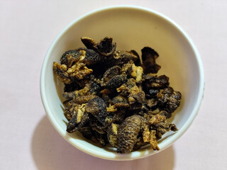 Flourless snail chips have a savory, delicious and crunchy taste. Presented with a white bowl with a natural blur background.