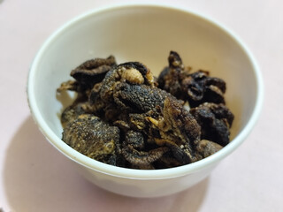 Flourless snail chips have a savory, delicious and crunchy taste. Presented with a white bowl with a natural blur background.