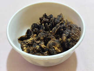 Flourless snail chips have a savory, delicious and crunchy taste. Presented with a white bowl with a natural blur background.