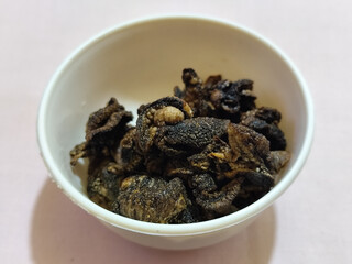 Flourless snail chips have a savory, delicious and crunchy taste. Presented with a white bowl with a natural blur background.