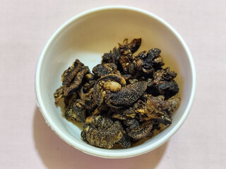 Flourless snail chips have a savory, delicious and crunchy taste. Presented with a white bowl with a natural blur background.