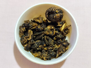 Flourless snail chips have a savory, delicious and crunchy taste. Presented with a white bowl with a natural blur background.