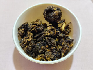 Flourless snail chips have a savory, delicious and crunchy taste. Presented with a white bowl with a natural blur background.