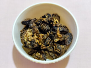 Flourless snail chips have a savory, delicious and crunchy taste. Presented with a white bowl with a natural blur background.