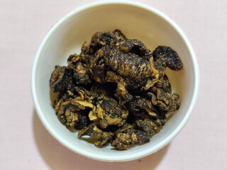 Flourless snail chips have a savory, delicious and crunchy taste. Presented with a white bowl with a natural blur background.