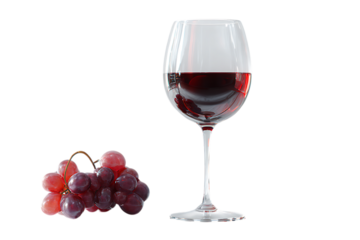 A glass of red wine next to a bunch of red grapes.