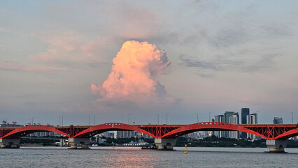 Obraz premium 서울 한강 성산대교 위로 떠오른 황금빛 뭉게구름