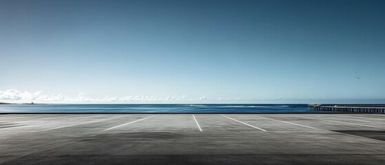 Obraz premium Scenic view of empty oceanfront parking lot under clear blue sky with overlooking ocean