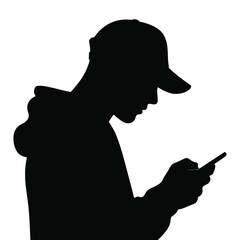 Silhouette of a young man wearing a baseball cap looking down at his smartphone © MDMINTU