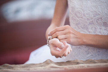 Bridal moments captured as a bride delicately adjusts her elegant bracelet before the ceremony in a serene setting