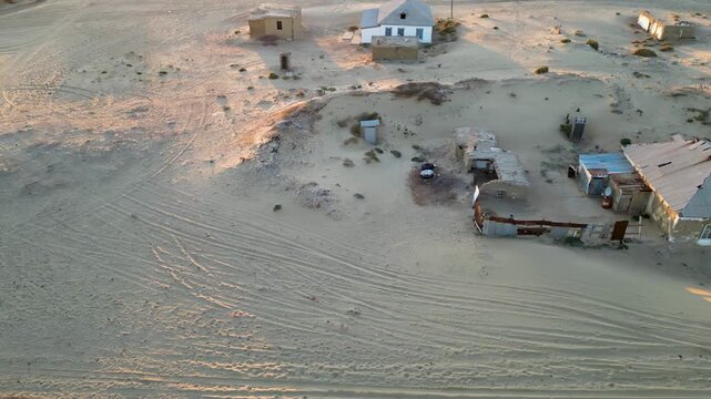 Akespe village at sunset. Once on the shore of the Aral Sea, it is now half buried in sand. Locals switched from fishing to camel herding as the sea vanished and desert took over.