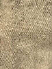 Plain Shirt of light beige fabric pattern. Close up view of urban minimalist style fashion shirt for men and women, fabric detail of seamless yellow color design 