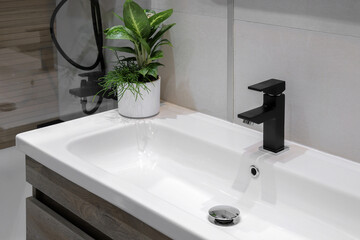 Faucet with white ceramic sink in the bathroom