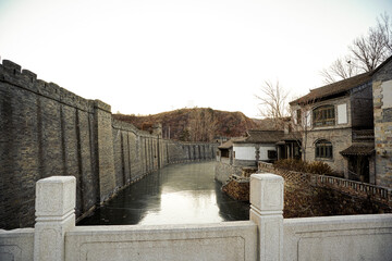 river flows between hills and houses, canal