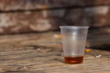 A Plastic Cup with Leftover Tea on a Wooden Surface