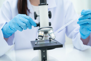 Scientist medical professional use microscope for research in science laboratory.