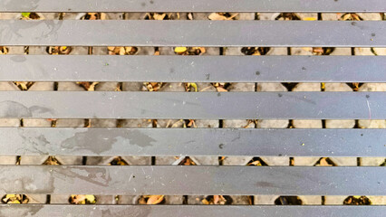 A weather-resistant, textured background for a small cafe table in a public park, made of iron. Durable, comfortable, and ideal for outdoor public spaces, parks, sidewalks, or recreational areas.