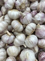 Garlic bulbs in a heap, showing natural textures and colors for food background use