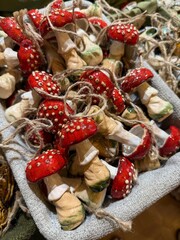 Red and white artificial mushrooms with twine accents in basket, earthy home decor concept