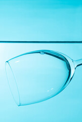 Glass in water isolated on blue background