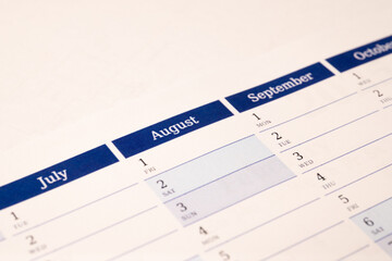 Close-up of calendar page with months
