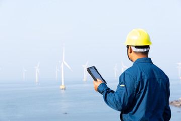 asian engineer working on digital tablet with  wind power