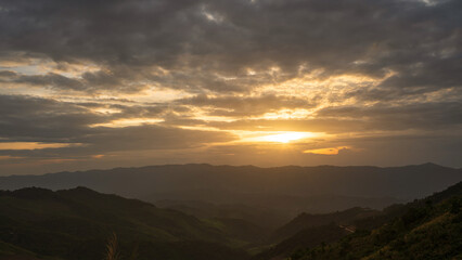 Orange sunset over the mountains landscape, cloudy sky