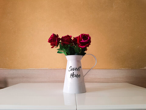 Elegant Red Roses in a White Vintage Pitcher on Minimalist Table, with Warm Toned Wall Background – Cozy and Aesthetic Home Interior Decoration

 - Powered by Adobe