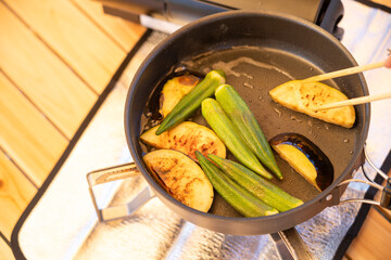 アウトドアキッチンで香ばしいなすを焼くキャンプ料理