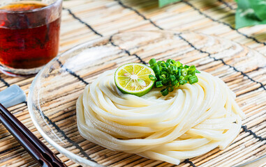すだちと青ねぎを添えたシンプルな冷やしうどんの夏向け和食