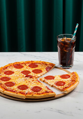 Close-up of a cheesy pepperoni pizza with a refreshing glass of cola.