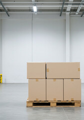 Cardboard boxes stacked on a pallet in a spacious warehouse, ready for shipping and storage.