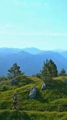 A determined runner navigates a lush, mountainous trail, embodying endurance and joy. The vibrant...