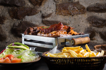 Peruvian Gastronomy, A plate of food with a salad and a basket of fries. The food is cooked and...