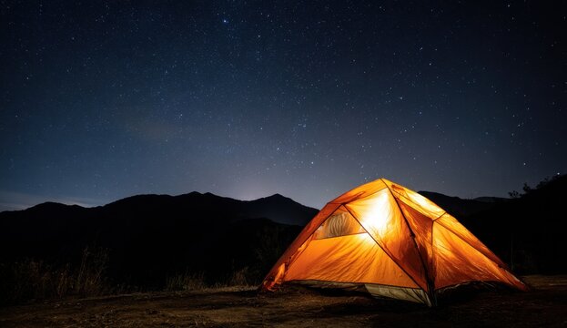 Illuminated tent glows warmly under a starlit night sky in a serene mountain landscape, inviting adventure and peaceful escape.