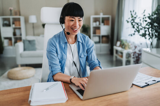 Asian freelancer woman working from home having video call on laptop