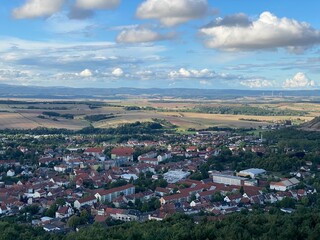 Aerial view of German villages in good weather, showing red roofs, green fields, and traditional European countryside landscape under a clear sky.