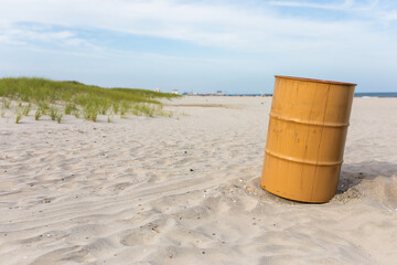 Naklejka premium a landscape of the sand dunes, a blue sky with white clouds, grasses and a yellow trash bin in the foreground on a beach in Ocean City, New Jersey 