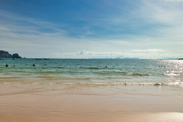 Railay Beach, Krabi Province, Thailand, 01 August 2025 : The beautiful seascape of sand beach, blue sky, sea and limestone mountains at seashore. Boats on turquoise waters. picture perfect hot day.
