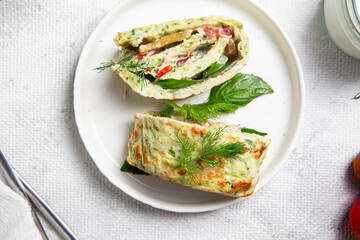 Appetizing zucchini roll with tomatoes and garlic on a light background