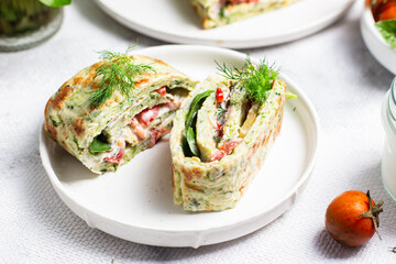 Appetizing zucchini roll with tomatoes and garlic on a light background