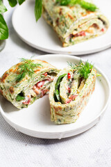 Appetizing zucchini roll with tomatoes and garlic on a light background
