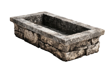 Rectangular stone water basin.  Features a  stone-like, light-gray, rectangular trough with a shallow,  water-filled basin.  A border of stacked stones surrounds the basin