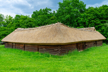 Obraz premium A typical Ukrainian ancient house covered with straw stands quietly, reflecting traditional rural architecture and cultural heritage in Ukraine.