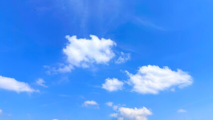 Blue sky background with white clouds in summer. Soft white clouds float in the clear blue sky. Clear blue sky, bright spring, soft sky gradient, wallpaper landscape, aerial view.